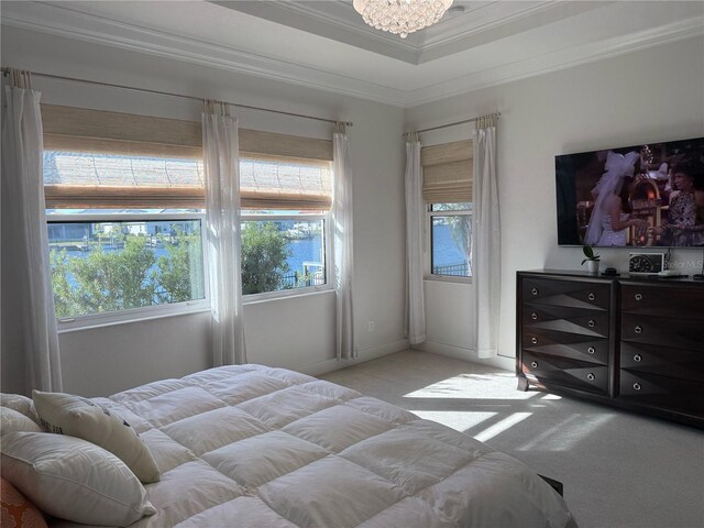 bedroom with light colored carpet, crown molding, a chandelier, a tray ceiling, and baseboards