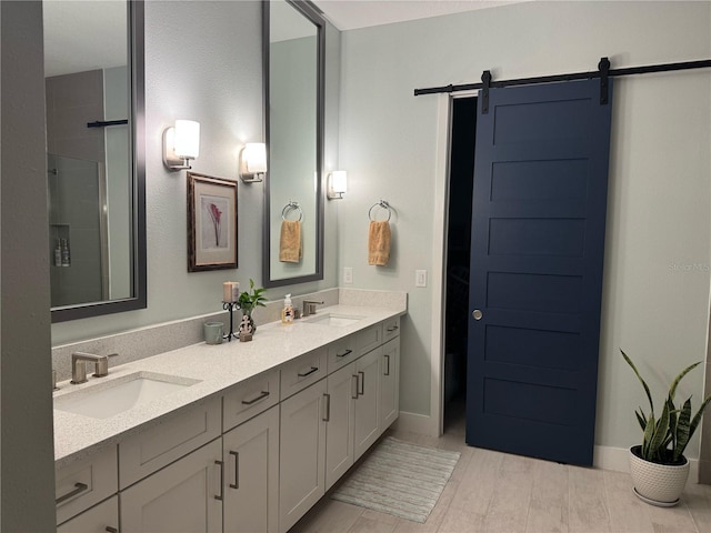 bathroom featuring a shower with shower door and double vanity