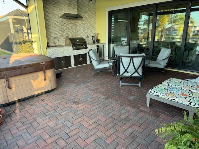 view of patio / terrace with an outdoor kitchen, area for grilling, outdoor dining space, a sink, and a hot tub