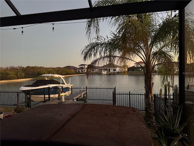 dock featuring a water view, fence, and a patio