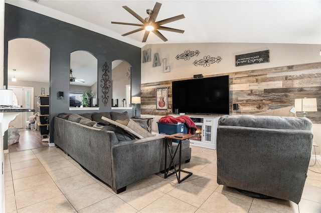 13416 Algoma Ave, Spring Hill, FL 34609 - living area featuring a ceiling fan, arched walkways, vaulted ceiling, light tile patterned floors, and wooden walls