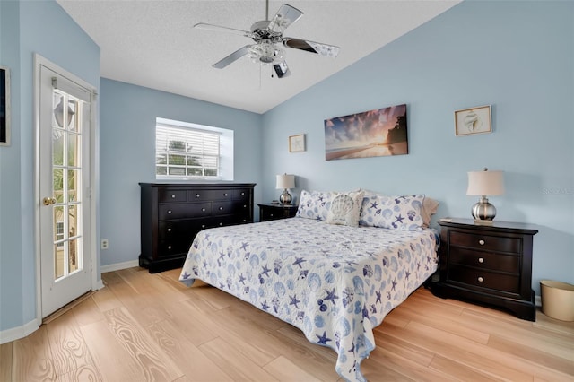 bedroom with vaulted ceiling, wood finished floors, a ceiling fan, and access to exterior