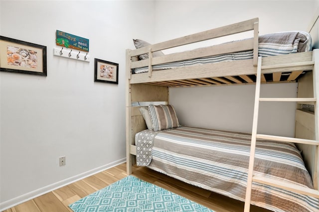 bedroom featuring baseboards and wood finished floors