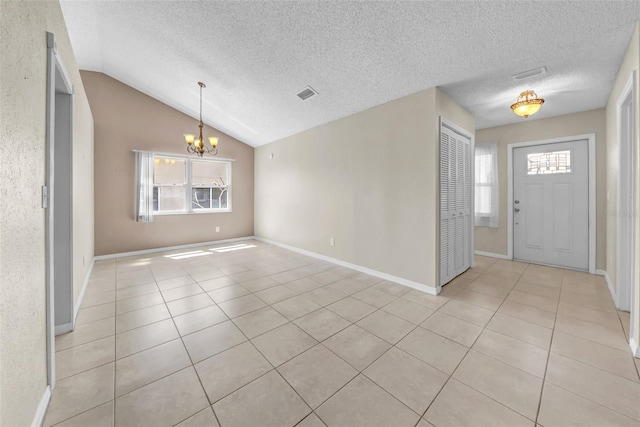 1969 Wolf Laurel Dr, Sun City Center, FL 33573 - entryway featuring light tile patterned floors, visible vents, a textured ceiling, and an inviting chandelier