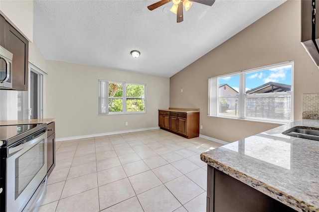 1969 Wolf Laurel Dr, Sun City Center, FL 33573 - kitchen with a textured ceiling, a ceiling fan, light stone counters, lofted ceiling, and stainless steel electric range