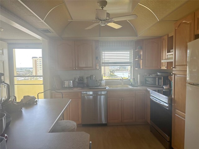 4725 Cove Cir Unit 810, Saint Petersburg, FL 33708 - kitchen featuring stainless steel appliances, a sink, wood finished floors, ceiling fan, and light countertops