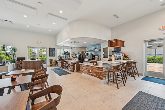 16709 Barnwood Pl, Bradenton, FL 34211 - kitchen with light tile patterned floors, a peninsula, high vaulted ceiling, recessed lighting, and arched walkways