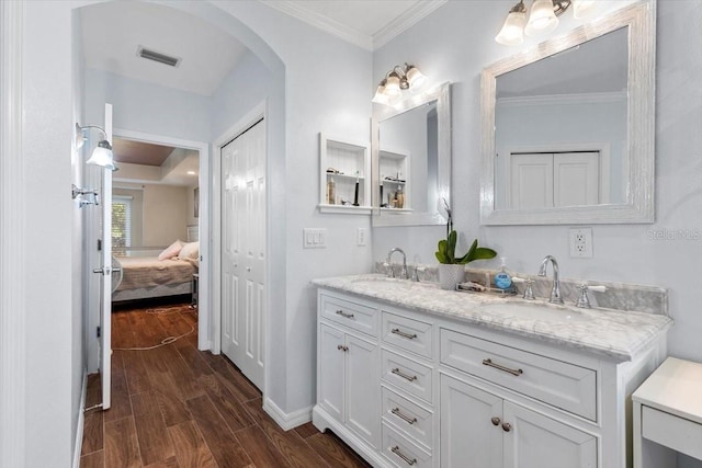 6230 Gannetdale Dr, Lithia, FL 33547 - ensuite bathroom featuring double vanity, wood finished floors, baseboards, and ornamental molding