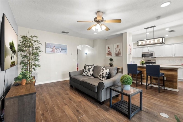 6230 Gannetdale Dr, Lithia, FL 33547 - living area featuring arched walkways, dark wood finished floors, ceiling fan, and recessed lighting