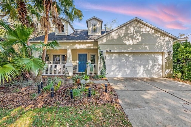 6230 Gannetdale Dr, Lithia, FL 33547 - view of front facade with an attached garage, covered porch, concrete driveway, and stucco siding