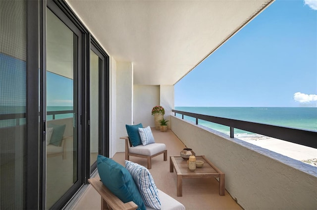 balcony featuring a beach view and a water view