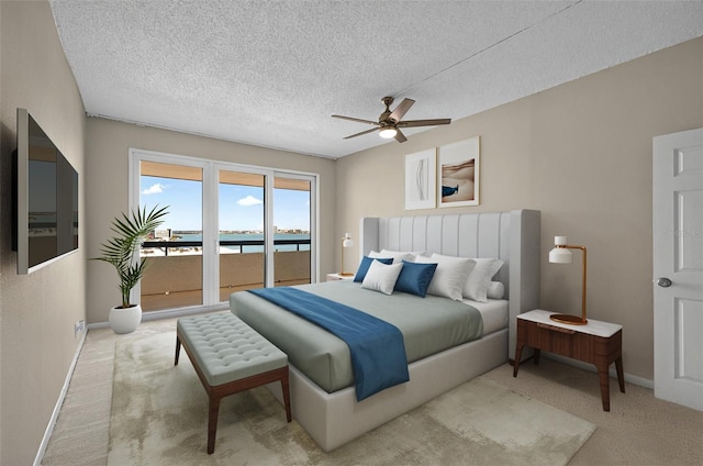 bedroom featuring a textured ceiling, carpet, access to outside, and baseboards