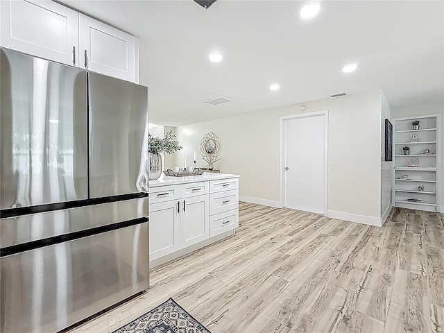 1469 S Hillcrest Ave, Clearwater, FL 33756 - kitchen featuring freestanding refrigerator, light wood-type flooring, white cabinets, baseboards, and recessed lighting