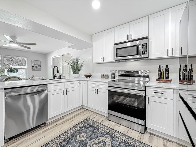 1469 S Hillcrest Ave, Clearwater, FL 33756 - kitchen featuring stainless steel appliances, a sink, light countertops, ceiling fan, and a peninsula