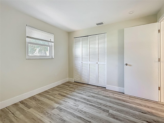 1469 S Hillcrest Ave, Clearwater, FL 33756 - unfurnished bedroom with a closet, wood finished floors, and baseboards