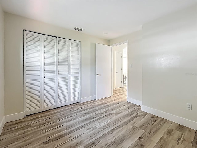 1469 S Hillcrest Ave, Clearwater, FL 33756 - unfurnished bedroom with light wood finished floors, a closet, and baseboards