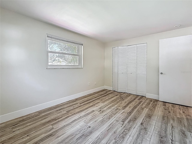 1469 S Hillcrest Ave, Clearwater, FL 33756 - unfurnished bedroom with wood finished floors, a closet, and baseboards