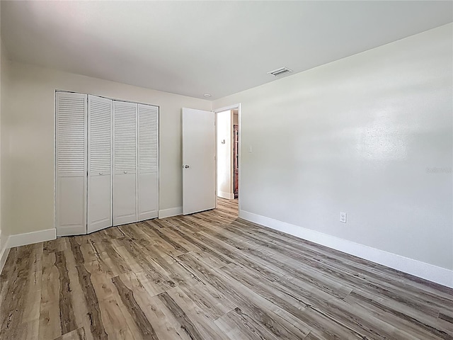 1469 S Hillcrest Ave, Clearwater, FL 33756 - unfurnished bedroom with wood finished floors, baseboards, and a closet