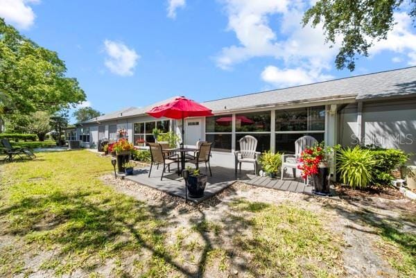 8244 Brentwood Rd, Seminole, FL 33777 - rear view of property with a lawn and a patio