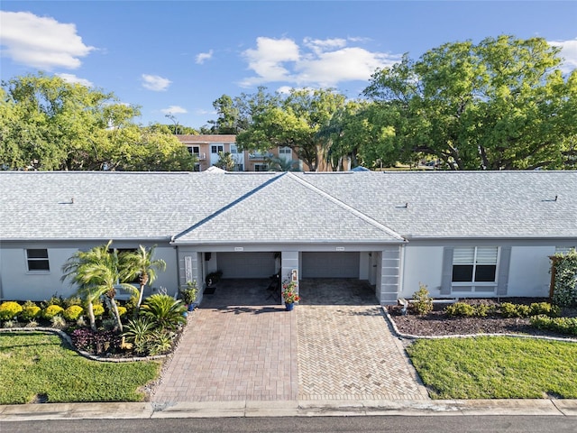8244 Brentwood Rd, Seminole, FL 33777 - single story home featuring decorative driveway, a garage, stucco siding, and roof with shingles