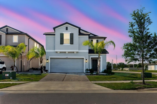 traditional-style home with concrete driveway, a yard, stucco siding, and a garage