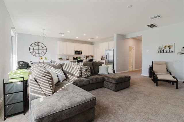 living area featuring a chandelier, visible vents, baseboards, and light colored carpet