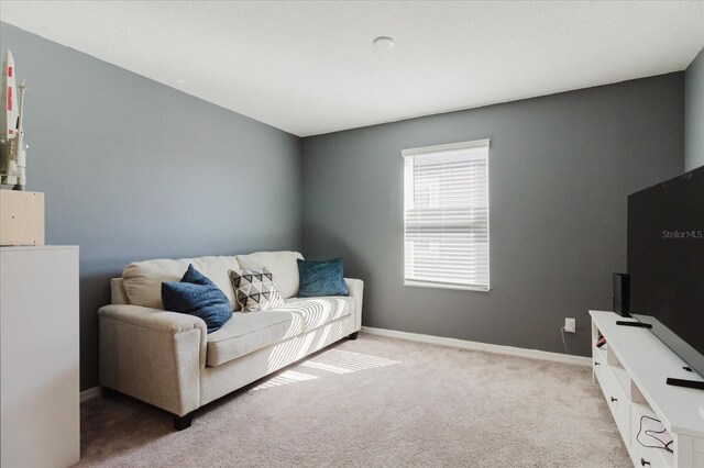 carpeted living area featuring baseboards