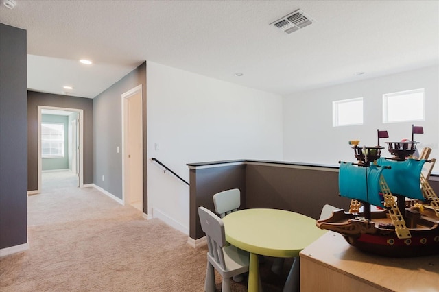 carpeted dining space with visible vents, baseboards, and plenty of natural light
