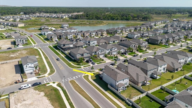 birds eye view of property featuring a water view, a wooded view, and a residential view