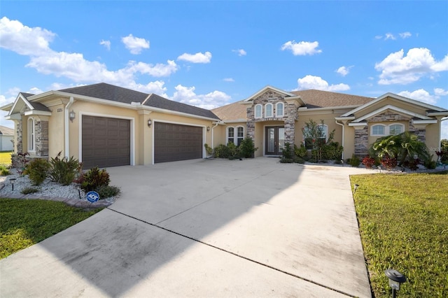 5325 San Remo Cir, Wimauma, FL 33598 - view of front of house featuring an attached garage, driveway, stucco siding, and stone siding
