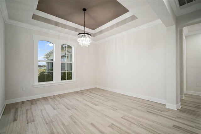 5325 San Remo Cir, Wimauma, FL 33598 - unfurnished room featuring a tray ceiling, wood finished floors, a notable chandelier, and baseboards