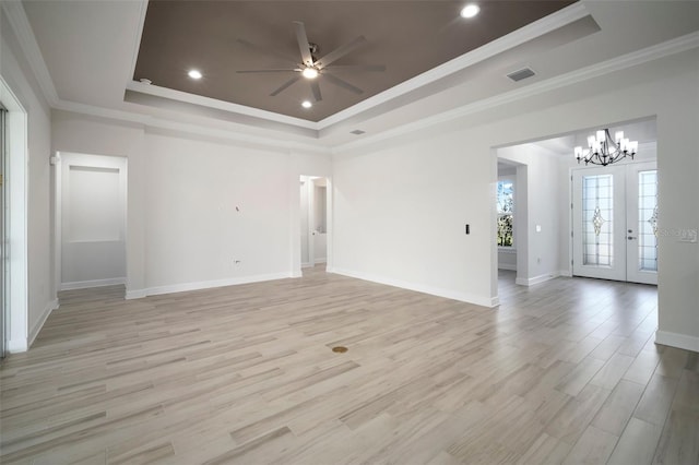 5325 San Remo Cir, Wimauma, FL 33598 - unfurnished living room featuring visible vents, crown molding, a tray ceiling, ceiling fan with notable chandelier, and light wood-style flooring