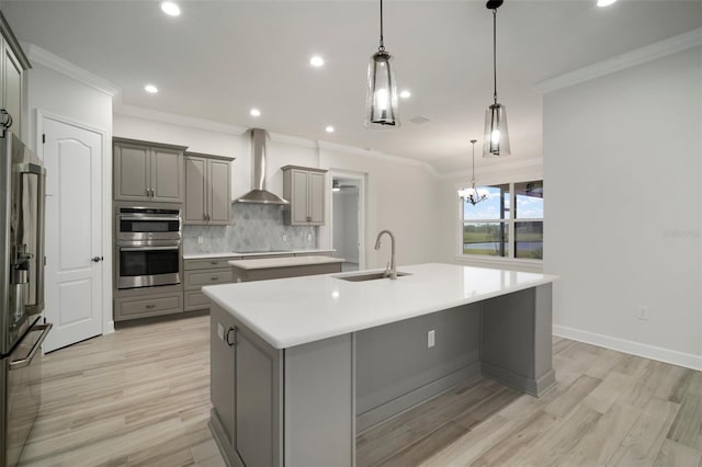 5325 San Remo Cir, Wimauma, FL 33598 - kitchen with wall chimney exhaust hood, a sink, an island with sink, stainless steel appliances, and gray cabinets