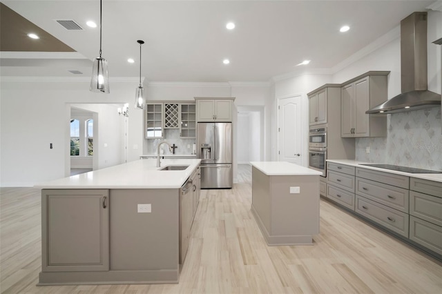 5325 San Remo Cir, Wimauma, FL 33598 - kitchen featuring wall chimney range hood, gray cabinets, a sink, stainless steel appliances, and a center island with sink