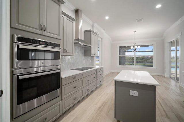 5325 San Remo Cir, Wimauma, FL 33598 - kitchen featuring black electric stovetop, wall chimney range hood, crown molding, stainless steel double oven, and gray cabinetry