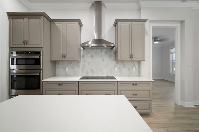 5325 San Remo Cir, Wimauma, FL 33598 - kitchen featuring ornamental molding, wall chimney range hood, black electric stovetop, and stainless steel double oven