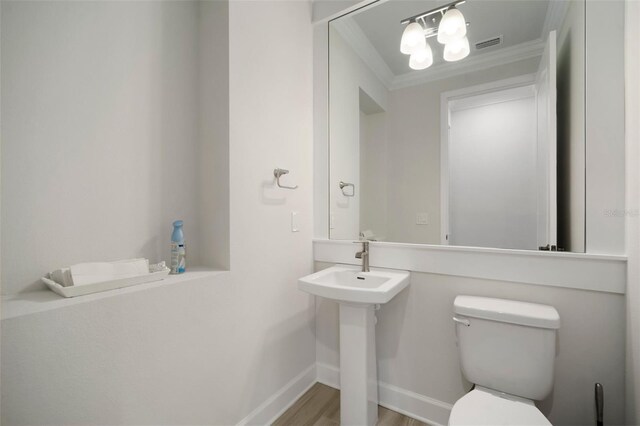 5325 San Remo Cir, Wimauma, FL 33598 - half bath featuring visible vents, baseboards, ornamental molding, toilet, and wood finished floors