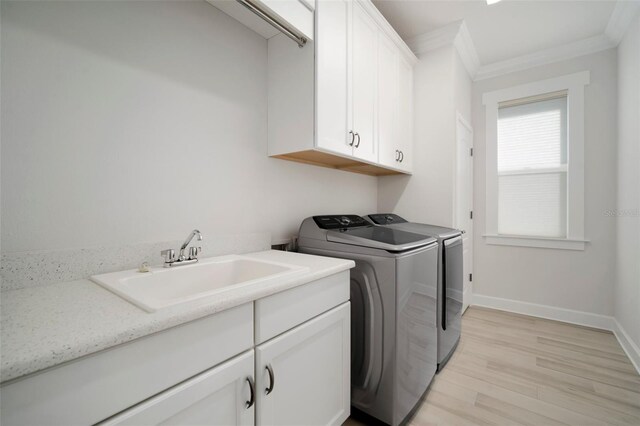 5325 San Remo Cir, Wimauma, FL 33598 - laundry room with crown molding, separate washer and dryer, a sink, light wood finished floors, and cabinet space