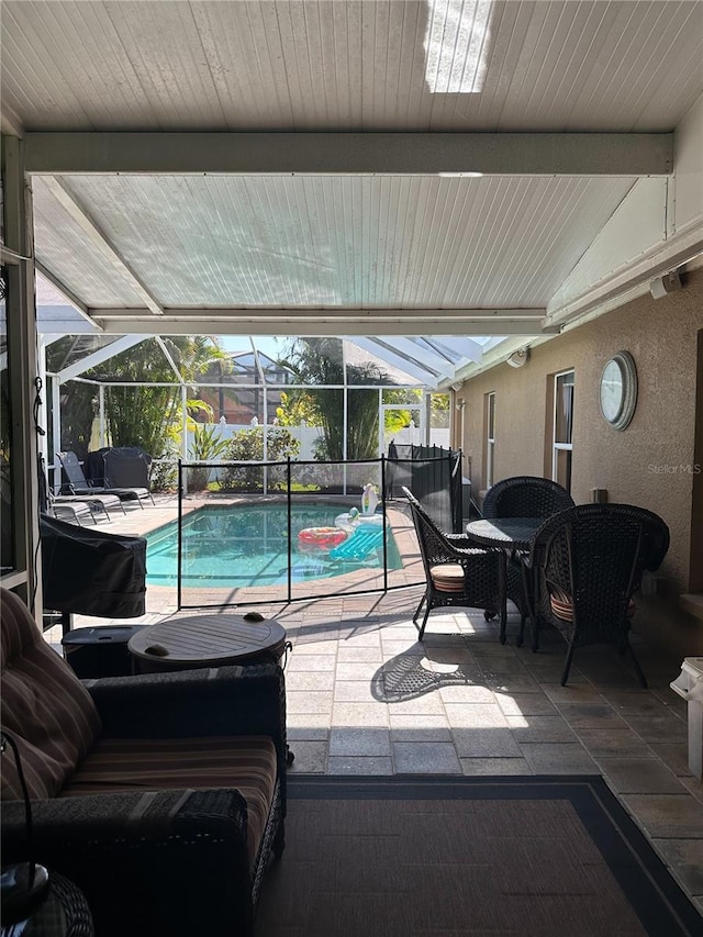outdoor pool featuring glass enclosure, a patio, and outdoor dining space