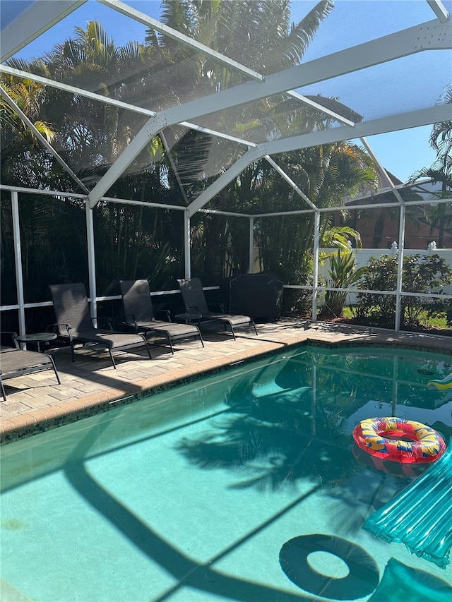pool with a lanai and a patio area