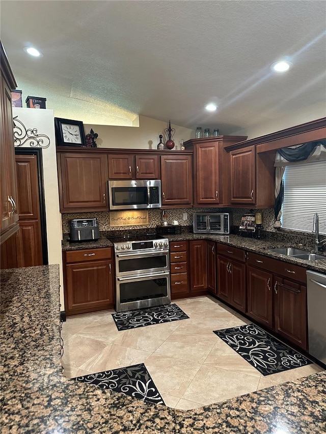 kitchen featuring a sink, tasteful backsplash, stainless steel appliances, and a toaster