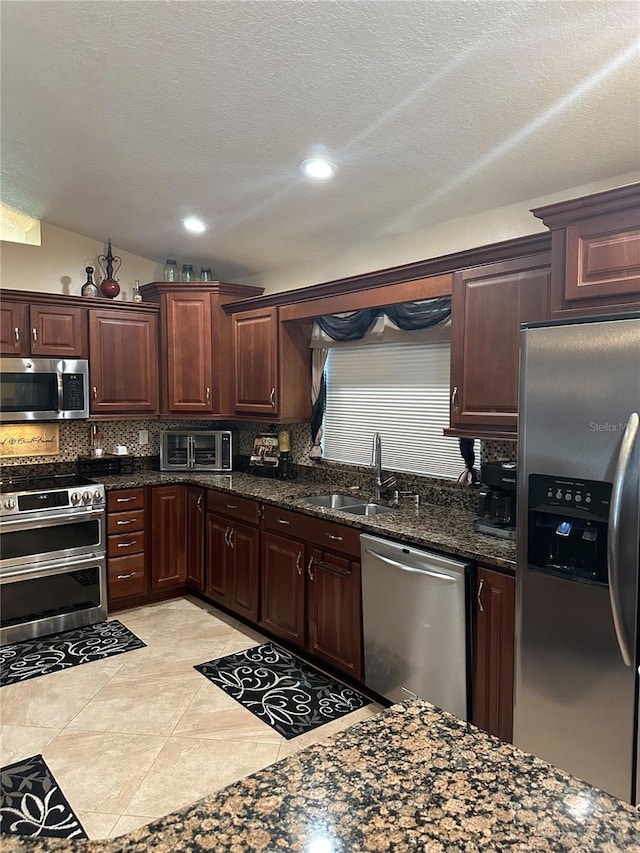 kitchen with decorative backsplash, a toaster, recessed lighting, a sink, and stainless steel appliances