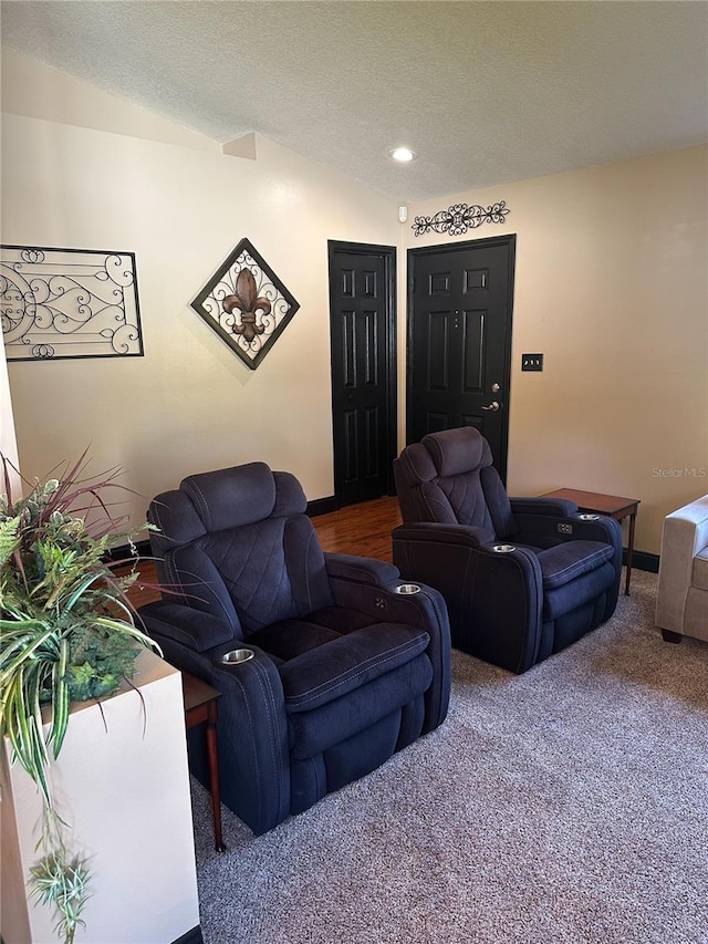 carpeted living area with recessed lighting, a textured ceiling, and baseboards