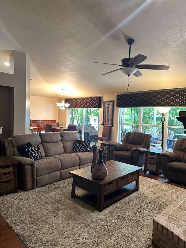 living room featuring a textured ceiling, wood finished floors, and ceiling fan with notable chandelier