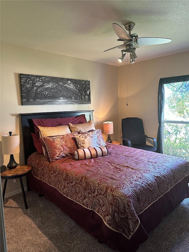 carpeted bedroom with a ceiling fan and a textured ceiling