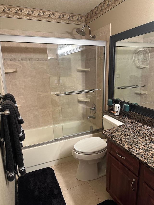bathroom featuring tile patterned floors, vanity, toilet, and shower / bath combination with glass door
