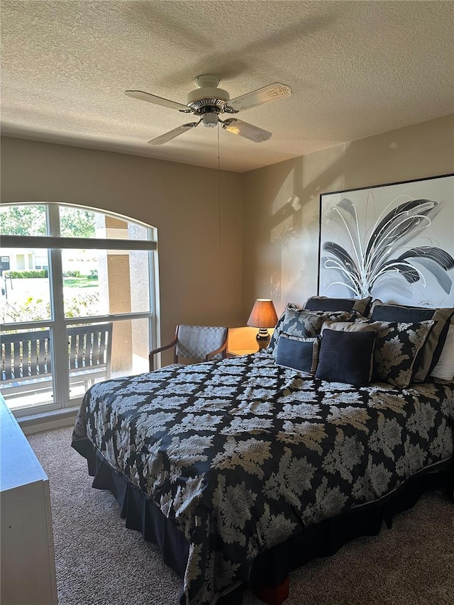 carpeted bedroom with a ceiling fan, a textured ceiling, and multiple windows