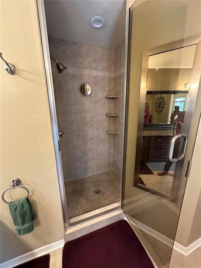 full bathroom with baseboards and a shower stall