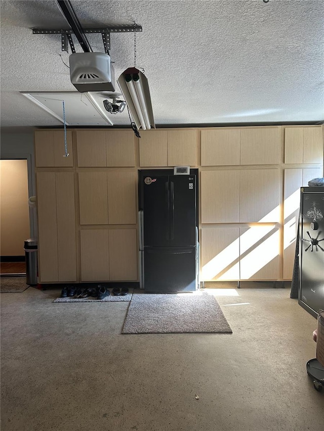 garage featuring a garage door opener and freestanding refrigerator