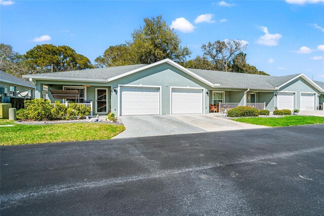 6745 Basswood Cir, Zephyrhills, FL 33542 - ranch-style home with driveway, a porch, a garage, and stucco siding